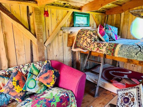 a room with a bed and a couch in a cabin at Wrens Nest in Saint Mabyn