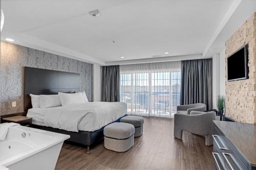 a hotel room with a bed and a tub and a sink at Hôtel Shediac in Shediac