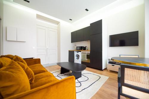un salon avec un canapé et une table dans l'établissement Elegant 1BR - Beaugrenelle - Javel, à Paris