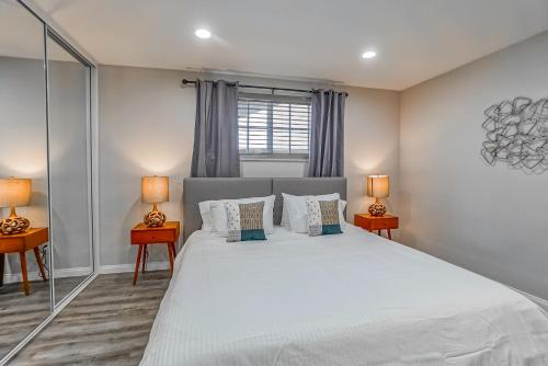 a bedroom with a large white bed with two lamps at F-65 Adventure House in Anaheim