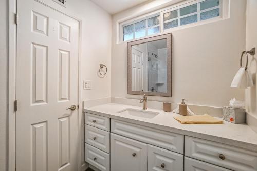 a white bathroom with a sink and a mirror at F-65 Adventure House in Anaheim