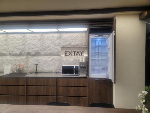 a kitchen with a sink and a microwave on a counter at Extay Dongdaemun in Seoul
