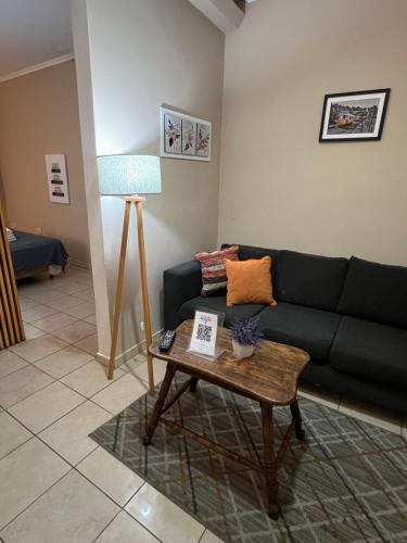 a living room with a black couch and a table at Departamento 1 interno - centro - Inst Cardiologico - cochera in Corrientes