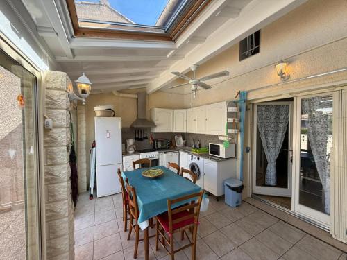 une cuisine avec une table et une cuisine avec un plafond dans l'établissement Maison de vacances 6 couchages, 2 chambres, mezzanine, wifi, 100m de la plage residence VILLAGE MER LRVM26, à Portiragnes