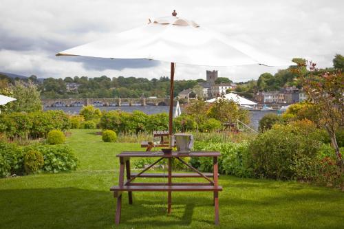 a table with an umbrella on the grass at The Lakeside Hotel & Leisure Centre in Killaloe