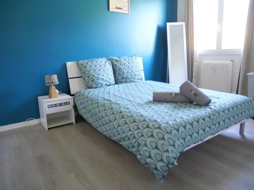 une chambre avec un lit et un mur bleu dans l'établissement Les Berceaux Thermal & Parking privé, à Royat