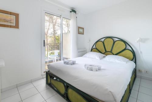 une chambre avec un grand lit et une grande fenêtre dans l'établissement L'Athéna By Tranquil at Home, à Pornichet