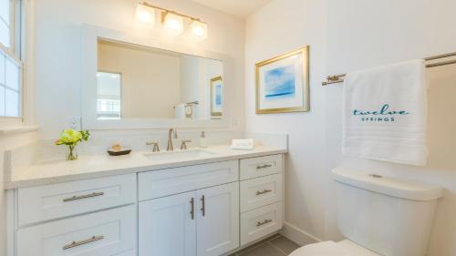 a white bathroom with a sink and a mirror at F-53 Trenton in Anaheim