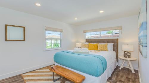 a bedroom with a blue and white bed and two windows at F-53 Trenton in Anaheim