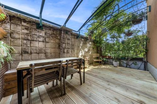 a patio with a wooden bench and a table at Isola Centrale FS Apartment 150 m METRO Marche in Milan