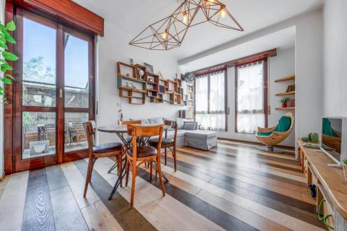 a living room with a table and chairs and windows at Isola Centrale FS Apartment 150 m METRO Marche in Milan