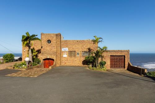 a brick house with a red door in front of the ocean at Hansmeyer Hill - 5 Bedroom House in Margate
