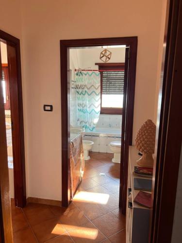a bathroom with a toilet and a window and a doorway at Atomos in Alvignano