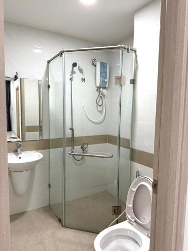 a bathroom with a shower with a toilet and a sink at Luxury Apartment Charm City in Dĩ An