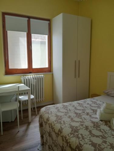 a bedroom with a bed and a desk and a table at B&Belvedere, affittacamere in San Benedetto del Tronto