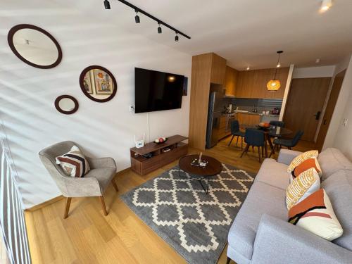 a living room with a couch and chairs and a tv at Londres #187 in Mexico City