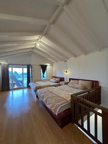 a bedroom with two beds and a large window at Aruna Dieng in Dieng
