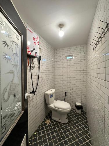 a bathroom with a white toilet in a room at Aruna Dieng in Dieng