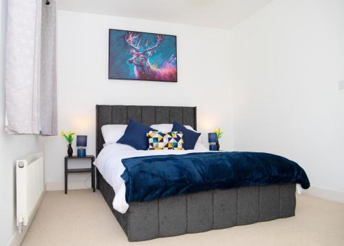 a bedroom with a bed with a blue comforter at Lavish 4-Bedrooms with Modern Home Features - Sleeps 8 - Hi-Speed Wi-Fi - Luxury Garden - Private Ample Parking in Peterborough