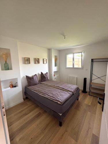 une chambre avec un grand lit dans une pièce dans l'établissement Au domaine des sources, à Grosbreuil