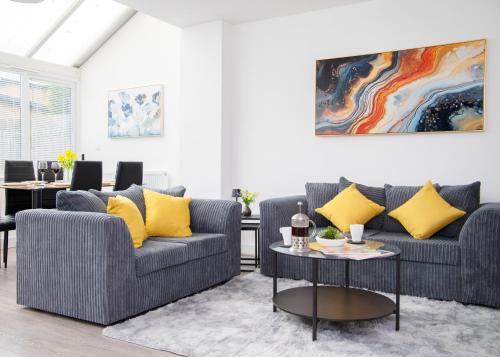 a living room with two couches and a table at Lavish 4-Bedrooms with Modern Home Features - Sleeps 8 - Hi-Speed Wi-Fi - Luxury Garden - Private Ample Parking in Peterborough