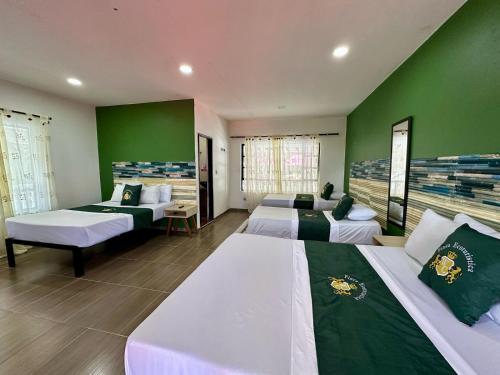 a bedroom with two beds and a green wall at Finca Hotel Windsor Campestre in Villavicencio