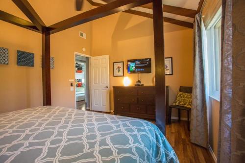 a bedroom with a bed and a television in it at Bedknobs and Broomsticks by Funtierland Vacation Rentals in Anaheim