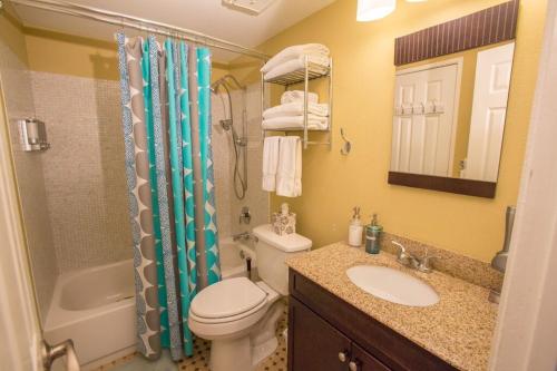 a bathroom with a toilet and a sink and a shower at Bedknobs and Broomsticks by Funtierland Vacation Rentals in Anaheim