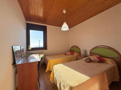 a room with two beds and a window at ROOMS El Descanso del Peregrino por la Costa in Oia