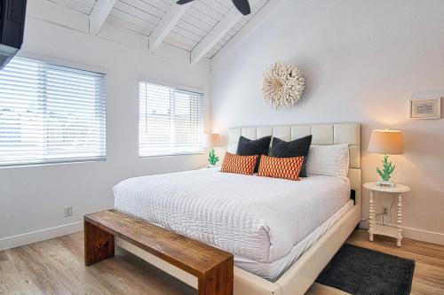 a bedroom with a white bed with orange pillows at New Suite Escapes 6 by Funtierland Vacation Rentals in Anaheim