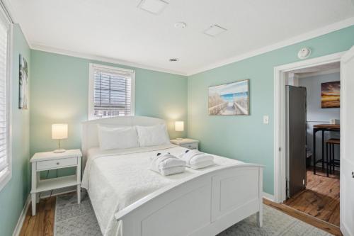 a bedroom with a white bed and a table at 23 Center St - Sunny Side Up - Upstairs Apartment in Folly Beach