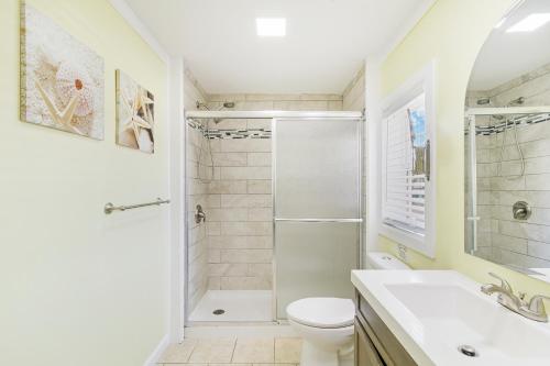 a bathroom with a shower and a toilet and a sink at 23 Center St - Sunny Side Up - Upstairs Apartment in Folly Beach