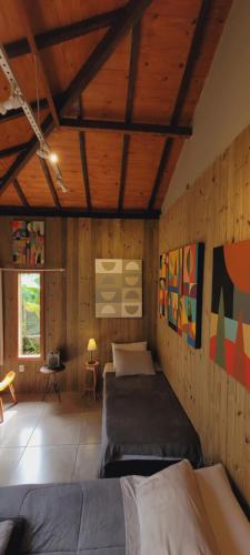 1 Schlafzimmer mit 2 Betten in einem Zimmer mit Holzwänden in der Unterkunft Casa Cor Tiradentes in Tiradentes