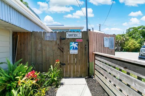 a fence with a sign on it next to a house at 23 Center St - Sunny Side Up - Upstairs Apartment in Folly Beach