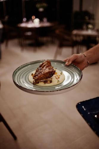 a person holding a plate with a piece of cake at Agriturismo Zapparè Farm Hotel in Trevignano