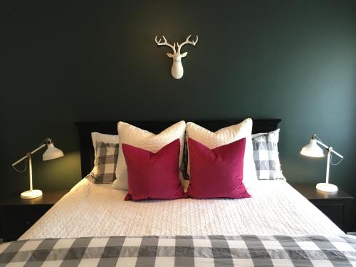 a bedroom with a bed with red pillows and two lamps at Arendelle by Funtierland Vacation Rentals in Anaheim