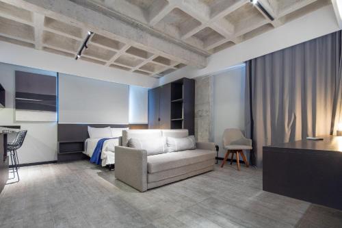 a living room with a couch and a bed at TOLIVE One Housi Recife by Carpediem in Recife