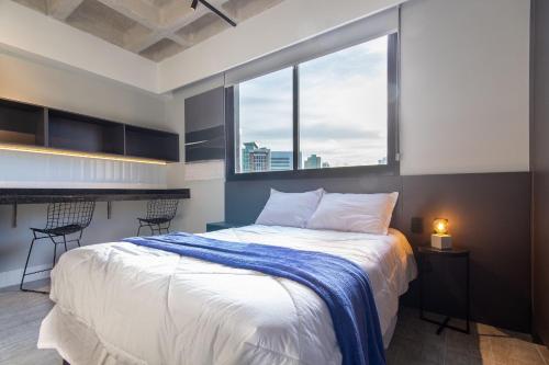 a bedroom with a large bed with a large window at TOLIVE One Housi Recife by Carpediem in Recife