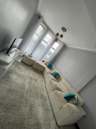 a living room with a couch and two windows at QD Apartment in Arusha