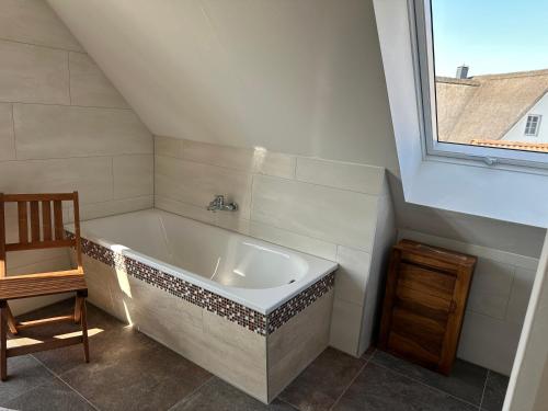 eine weiße Badewanne in einem Badezimmer mit Fenster in der Unterkunft Seestern in Dassow