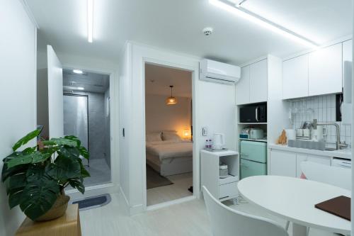 a white kitchen with a white table and a bed at Forest Hangang in Seoul