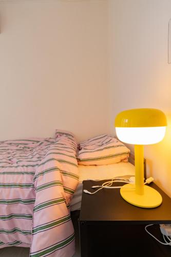 a bedroom with a bed and a yellow lamp on a table at Forest Hangang in Seoul