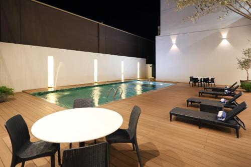a swimming pool with tables and chairs and a table and a table and chairs at Holiday Inn Navojoa by IHG in Navojoa