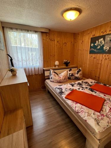 a bedroom with a bed in a wooden room at Bungalowdorf Briesensee in Neu Zauche