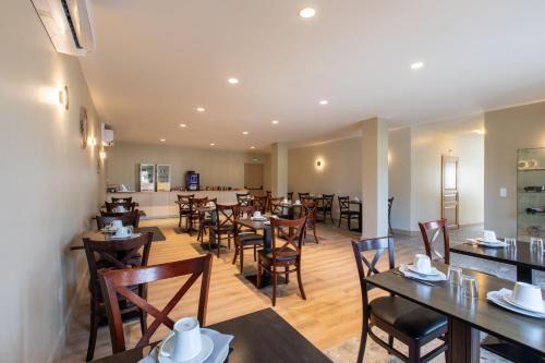 une salle à manger avec des tables et des chaises en bois dans l'établissement Domaine de la Courbe Hôtel & Spa, au Lude