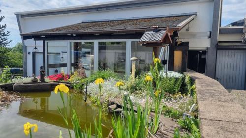 a garden in front of a house with a pond at Ferienwohnung Oberburg in Solingen