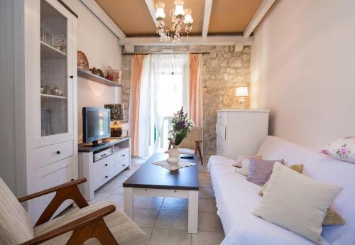 a living room with a white couch and a table at Visilo Stone House in Pučišća