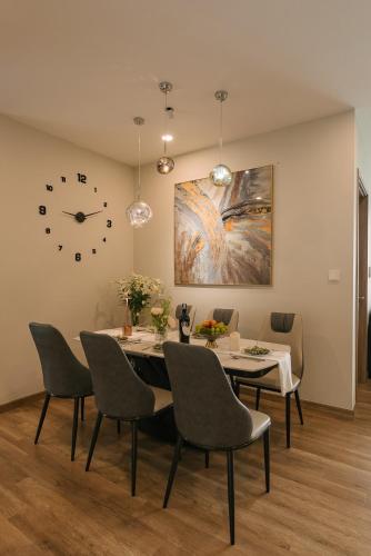 a dining room with a table and chairs and a clock at -20 Off I Beloving Home I 3BR Lakeview I Onsen I Golf View in Cong Luận