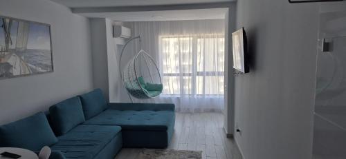 a living room with a blue couch and a window at Olimp sea view apartments - 802 in Olimp