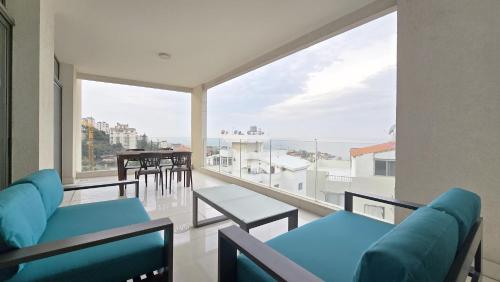 a balcony with blue chairs and a view of the ocean at Tabarja Hills apartment in ‘Ayn aş Şughayrah
